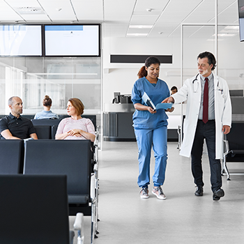 Doctor and assistant walking through hospital waiting room