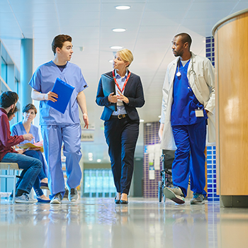 Healthcare providers discussing their network participation while walking the hallway